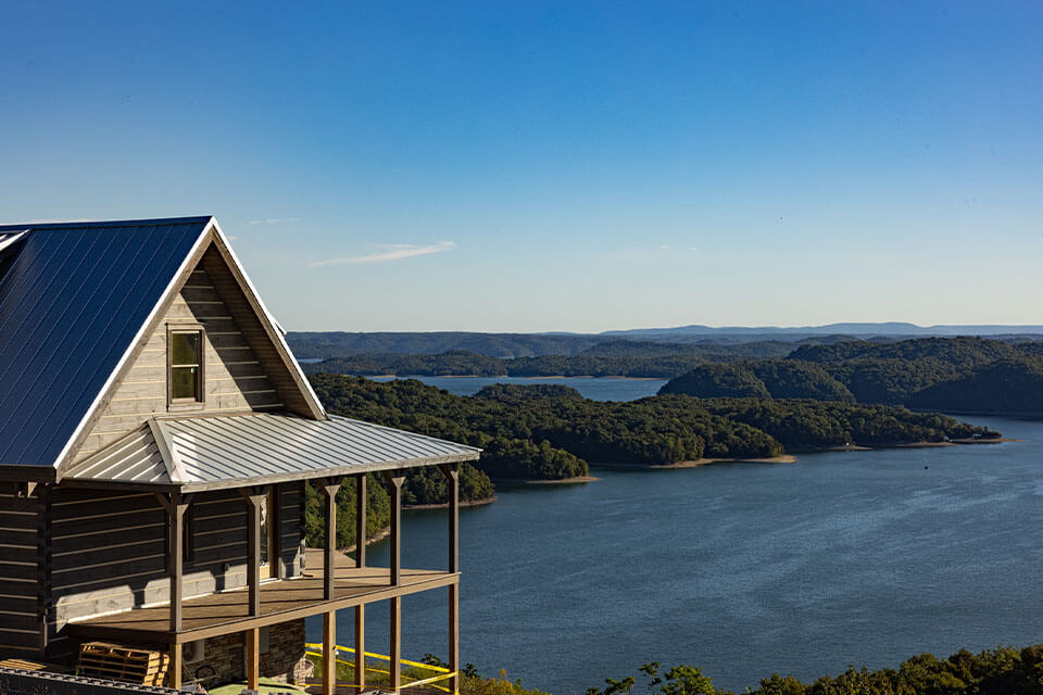 View of the Ocampo Family log cabin with water and greenery in the background